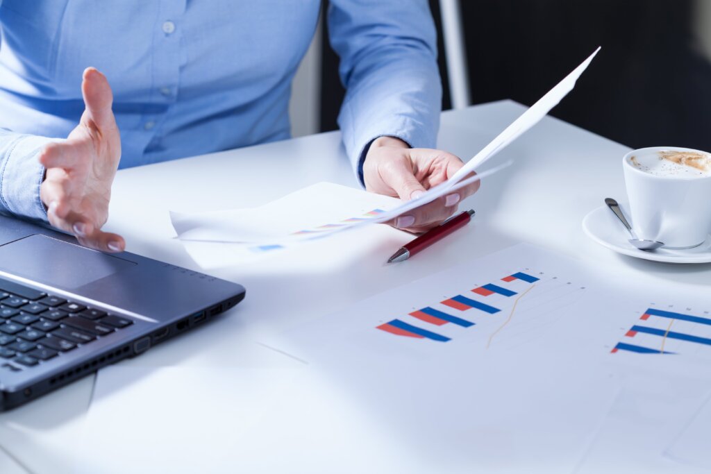 a man holds a piece of paper in his hand against the background of a diagram